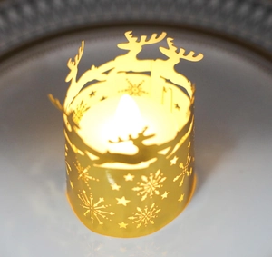 Close-up of golden Christmas reindeer hollow cutout metal sleeve with warm LED light