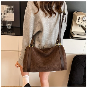 Dettaglio borsa tote in pelle opaca marrone scuro con hardware dorato e tracolla