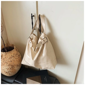 Minimalist cream white oil wax leather hobo tote bag hanging on wooden door