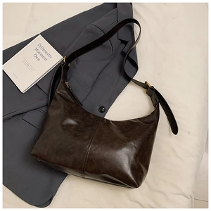 Detail view of dark brown hobo bag with vintage texture and golden metal buckle