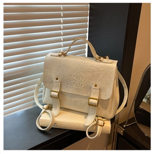 Detailed macro of cream faux leather backpack with embossed logo and metal buckles