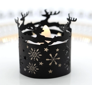 Close-up of black Christmas candle holder with reindeer and snowflake cutout patterns