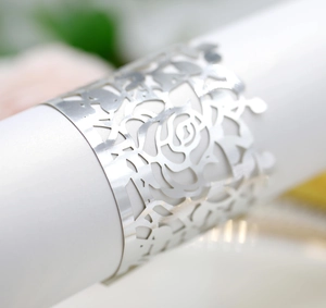Macro shot of silver hollow-out napkin ring with elegant laser-cut rose patterns