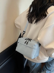 Light blue nylon crossbody bag with adjustable strap and front zipper pocket