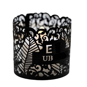 Black laser-cut candle holder sleeve with tropical leaf patterns and E-UB lettering