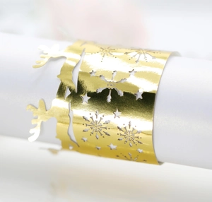 Macro shot of gold laser-cut paper napkin rings with Christmas elk and snowflake patterns