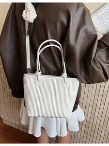 Chic beige pleated tote bag with round handles and strap, stylish commuting bucket bag