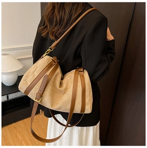Dettaglio della grande borsa tote kaki con cinturini in pelle marrone e fibbia dorata