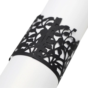 Elegant black laser-cut paper napkin ring with floral vine pattern for wedding decor