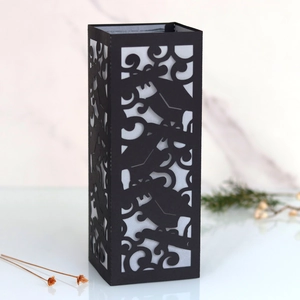 Detail of laser-cut black cardstock lampshade featuring mortarboard and floral scroll patterns