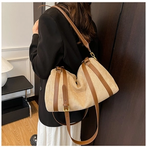 Dettaglio della borsa beige con finiture in pelle marrone e fibbie dorate regolabili