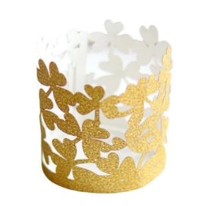 Detailed macro view of golden glitter clover laser-cut cupcake wrapper for party decor