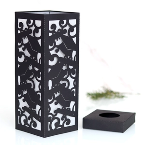 Detail view of laser-cut black paper lantern with floral hollow pattern and square base