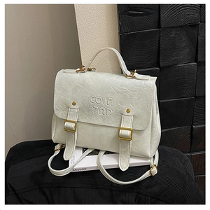 Detailed close-up of white wrinkled PU leather texture and vintage gold buckle on the bag