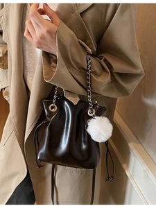 Sac seau en cuir marron foncé avec bandoulière chaîne et pompon doux élégant