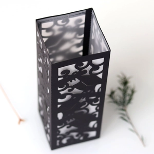 Detail view of laser-cut black paper candle shade with elegant floral pattern