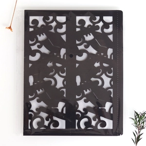Detail view of laser-cut black paper lantern sleeve with elegant scroll patterns
