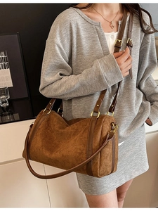 Borsa tote cilindrica in camoscio marrone con tracolla regolabile vista da un angolo di 45 gradi