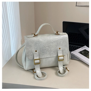 Detail of vintage grey leather backpack featuring textured finish and COIN 7RD embossing