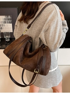 Borsa tote in camoscio marrone con tracolla in pelle indossata da modella su sfondo bianco