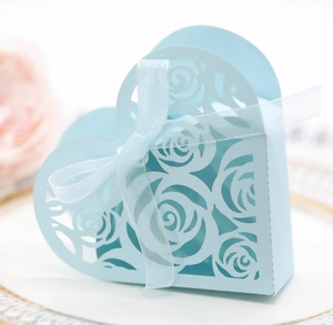 Light blue hollow heart-shaped wedding favor box with laser-cut rose patterns and ribbon