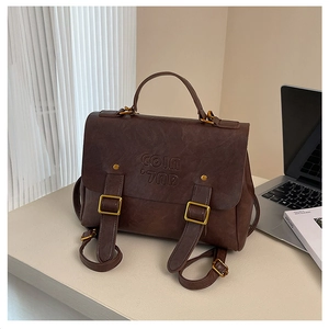 Detailed close-up of vintage brown PU leather backpack with COIN brand embossing and buckles