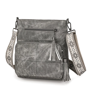 Detail view of grey vintage crossbody bag featuring double tassels and jacquard strap