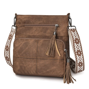 Detail of a brown vintage crossbody bag featuring a wide woven snowflake pattern strap