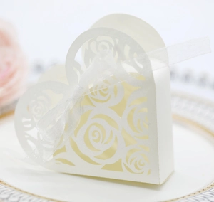 Macro detail of laser-cut rose patterns on a heart-shaped pearl white candy gift box