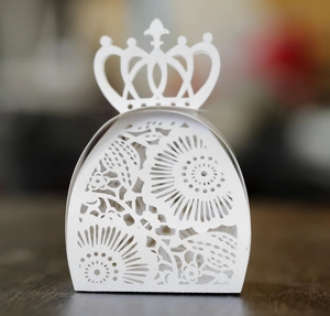 Vista macro di una scatola regalo bianca con intagli laser a corona e motivi floreali