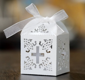 Primo piano di una scatola regalo bianca tagliata al laser con design a croce e nastro