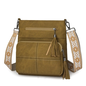 Detail of canvas crossbody bag with jacquard shoulder strap and long tassel zippers