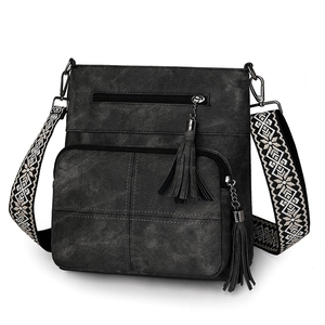 Detail of dark grey crossbody bag with fringe zippers and embroidered geometric wide strap