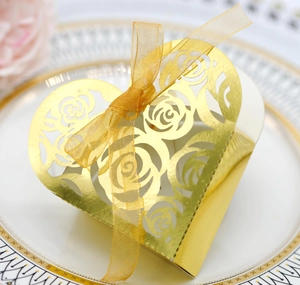 Macro shot of gold hollow heart gift box with laser-cut rose patterns and organza ribbon
