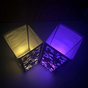 Macro shot of laser-cut paper lantern shades with geometric patterns and ambient lighting