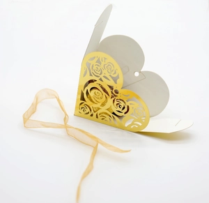 Detailed laser-cut hollow rose pattern on a golden heart-shaped wedding gift box