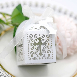 Elegant white laser-cut wedding favor candy box with cross pattern and ribbon