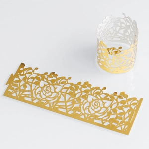 Detail of laser-cut rose pattern napkin rings in bright gold finish for festive party decor