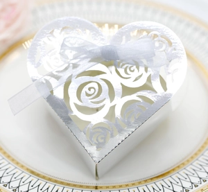 Detail of silver laser-cut hollow rose candy box with a white silk bow decoration