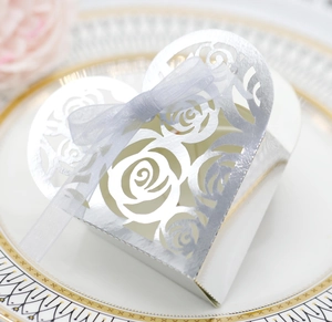 Close-up of heart-shaped hollow candy box with laser-cut rose patterns and ribbon