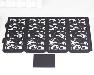 Detail showing black laser-cut graduation paper lampshade with mortarboard pattern and card