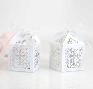 White laser-cut cross favor boxes with translucent ribbons for wedding and celebrations