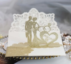 Détail de l'invitation de mariage découpée au laser avec silhouette Mr & Mrs dorée pailletée