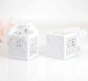 Detail of white laser-cut hollow chocolate gift box with ribbon and cross pattern