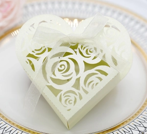 Detail of cream heart-shaped gift box with laser-cut rose patterns and white chiffon ribbon