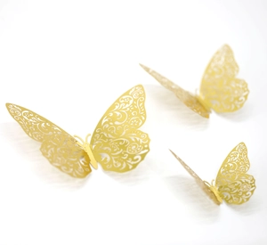 Three gold 3D hollow butterfly wall stickers with intricate laser-cut floral patterns