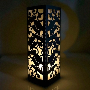 Elegant black laser-cut hollow paper lampshade with warm yellow LED candle glow