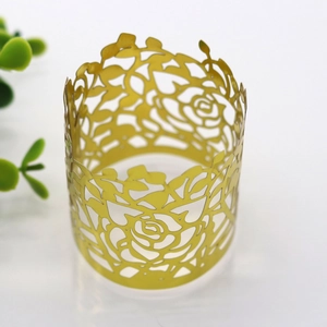 Close-up of golden hollowed-out rose pattern napkin ring with laser-cut floral design