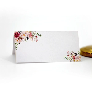 Detail of white wedding place card with elegant watercolor floral printing and folded design