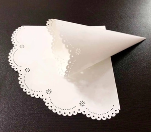 Detailed laser-cut hollow lace white paper doilies showing flat and cone shapes